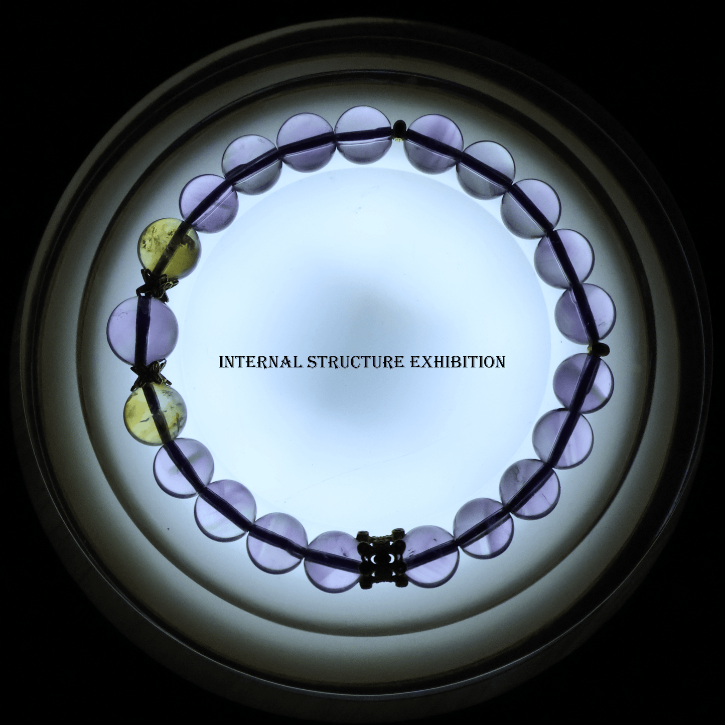 Translucent Pure Amethyst & Tajing Bracelet I backlit to reveal the internal structure of the gemstone beads.
