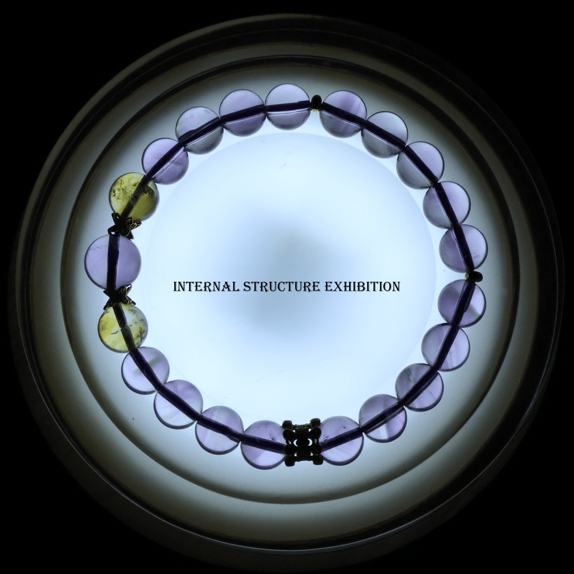 Translucent Pure Amethyst & Tajing Bracelet I backlit to reveal the internal structure of the gemstone beads.