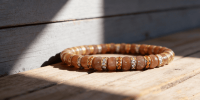Gold Sunstone Bracelet II (straight-cut) on the wood desk under the sunshine light