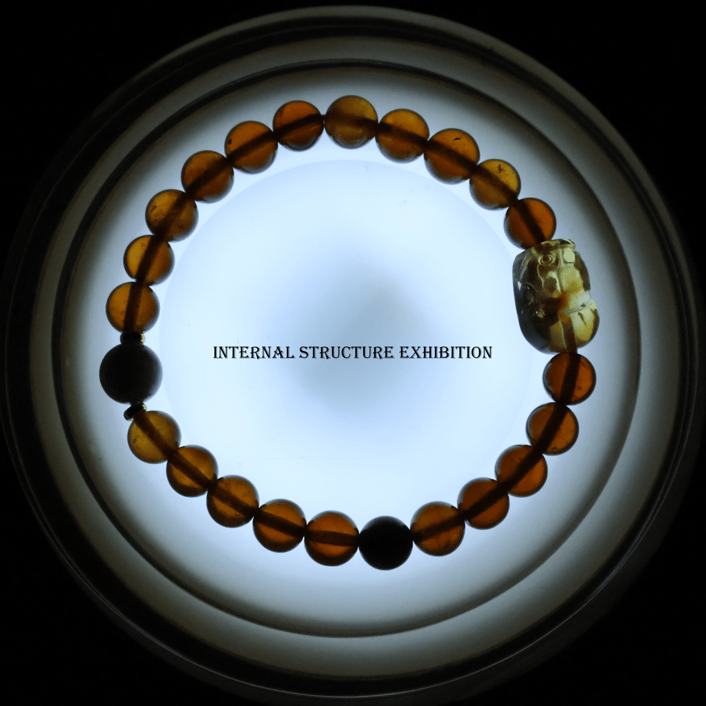 Orange Garnet Bracelet with Pixiu I on white background, which shows internal structure