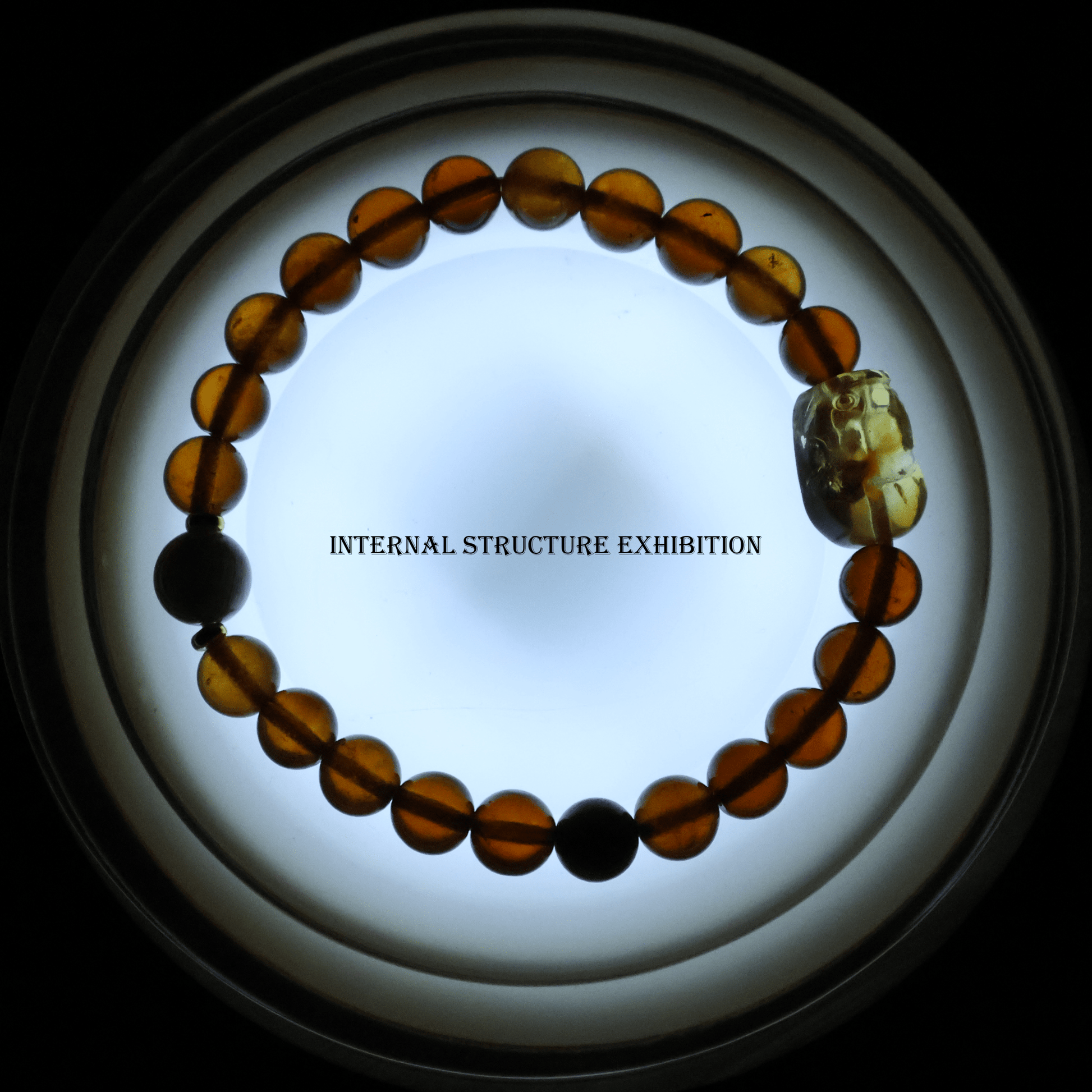 Orange Garnet Bracelet with Pixiu I on white background, which shows internal structure